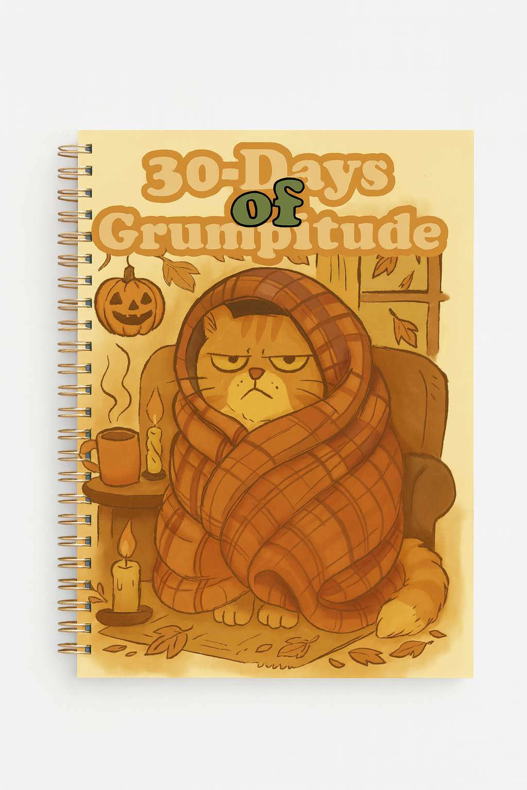 Grumpy orange cat wrapped in a plaid blanket sitting in a cozy armchair with candles, falling leaves, a pumpkin mug, and jack-o’-lantern decor, featured on the illustrated autumn-themed cover of the 30-Days of Grumptitude spiral journal.