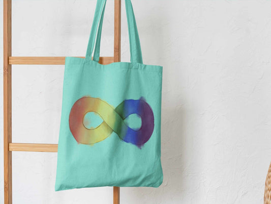 Person holding Autism Infinity cotton tote bag with neurodiversity symbol, reusable shopping bag for autism awareness