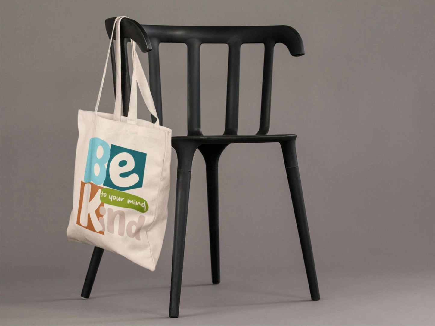 Person holding Be Kind to Your Mind cotton tote bag with mental health awareness message, reusable shopping bag