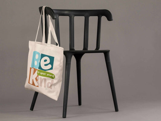 Person holding Be Kind to Your Mind cotton tote bag with mental health awareness message, reusable shopping bag