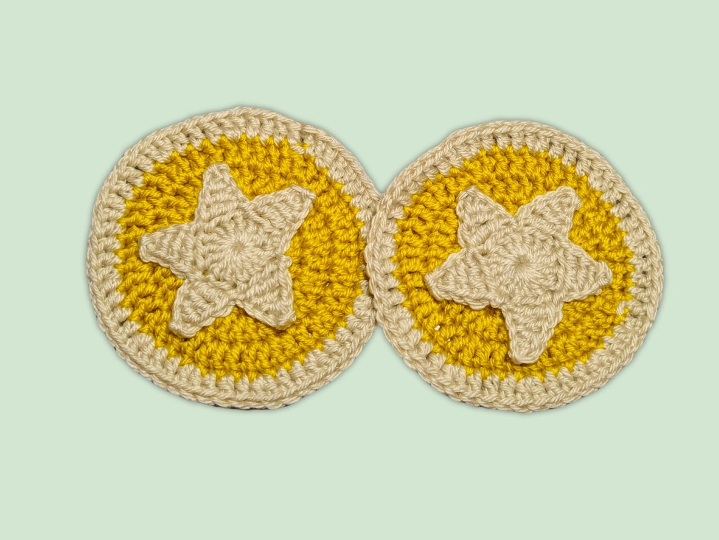 Crochet Nook Coin Coaster front with yellow and red yarn in a bell coin design, Animal Crossing-inspired.