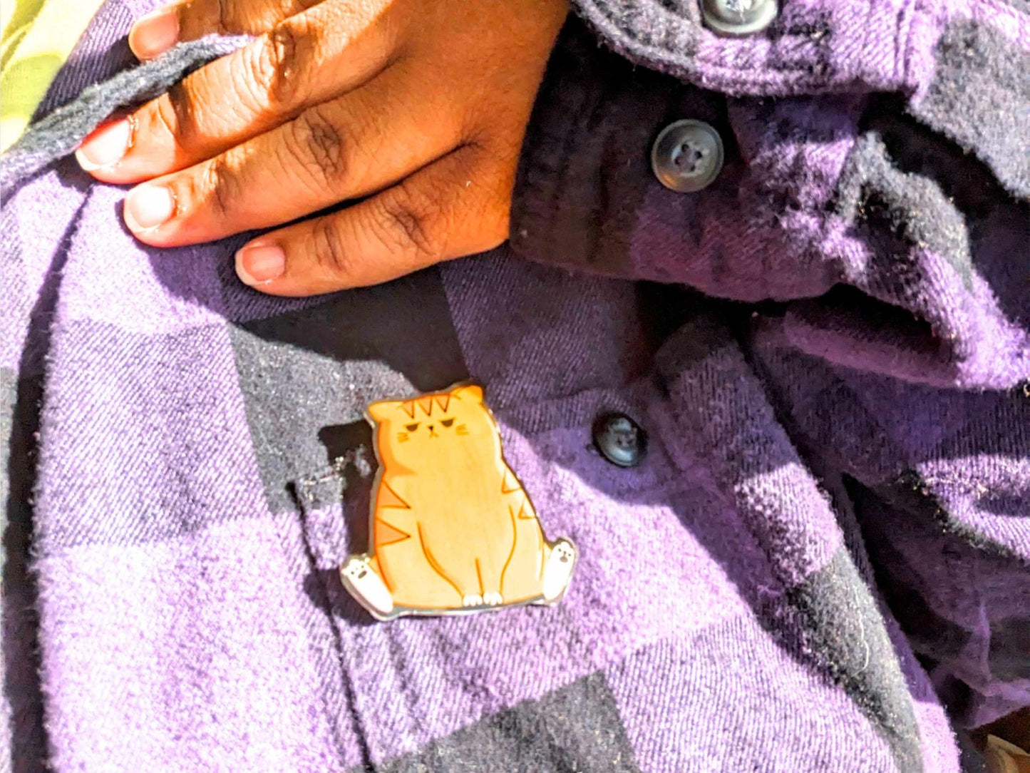 Mr. Grump Cat wooden pin worn on a jacket – a 2-inch wooden pin featuring a grumpy orange cat, a fun and quirky accessory for backpacks, lapels, and cat lovers.