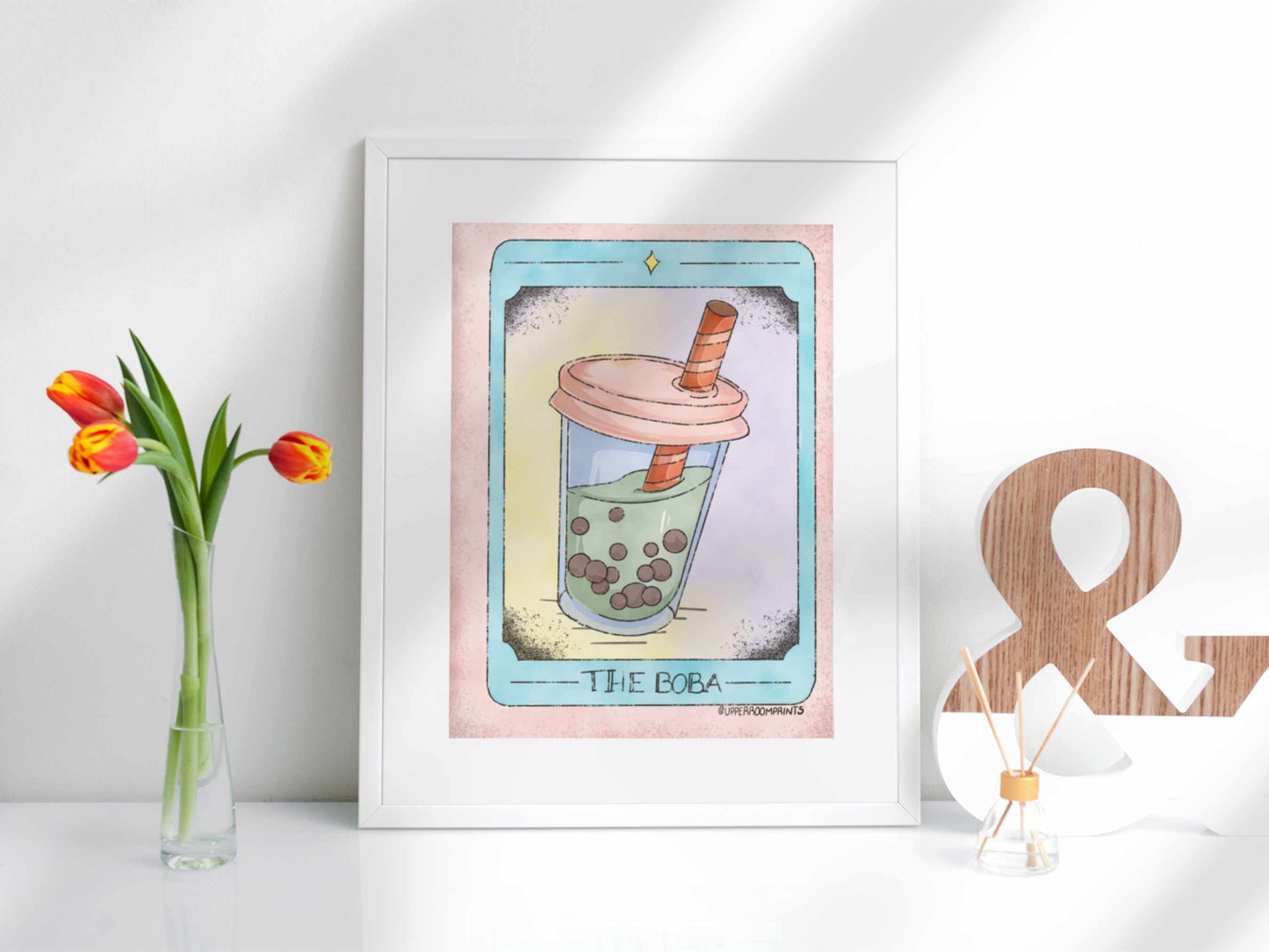 Tarot Boba Print framed on display, showing a whimsical matcha boba tea illustration in tarot card style