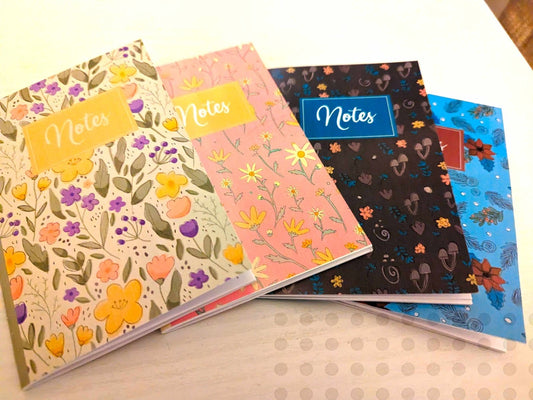 Four floral notebooks in a row showing spring, summer, fall, and winter cover illustrations from the Seasons Flowers Bundle