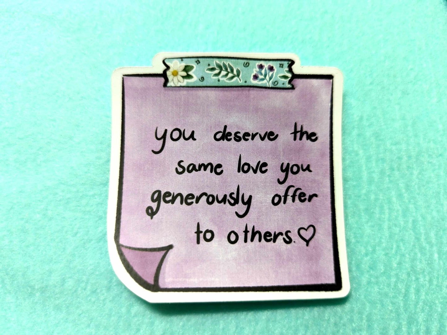 Close-up of the You Deserve Sticker, showcasing its uplifting design and high-quality waterproof vinyl finish