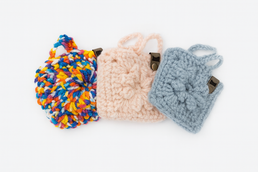 Three knitted pouches in colorful yarn on a white background