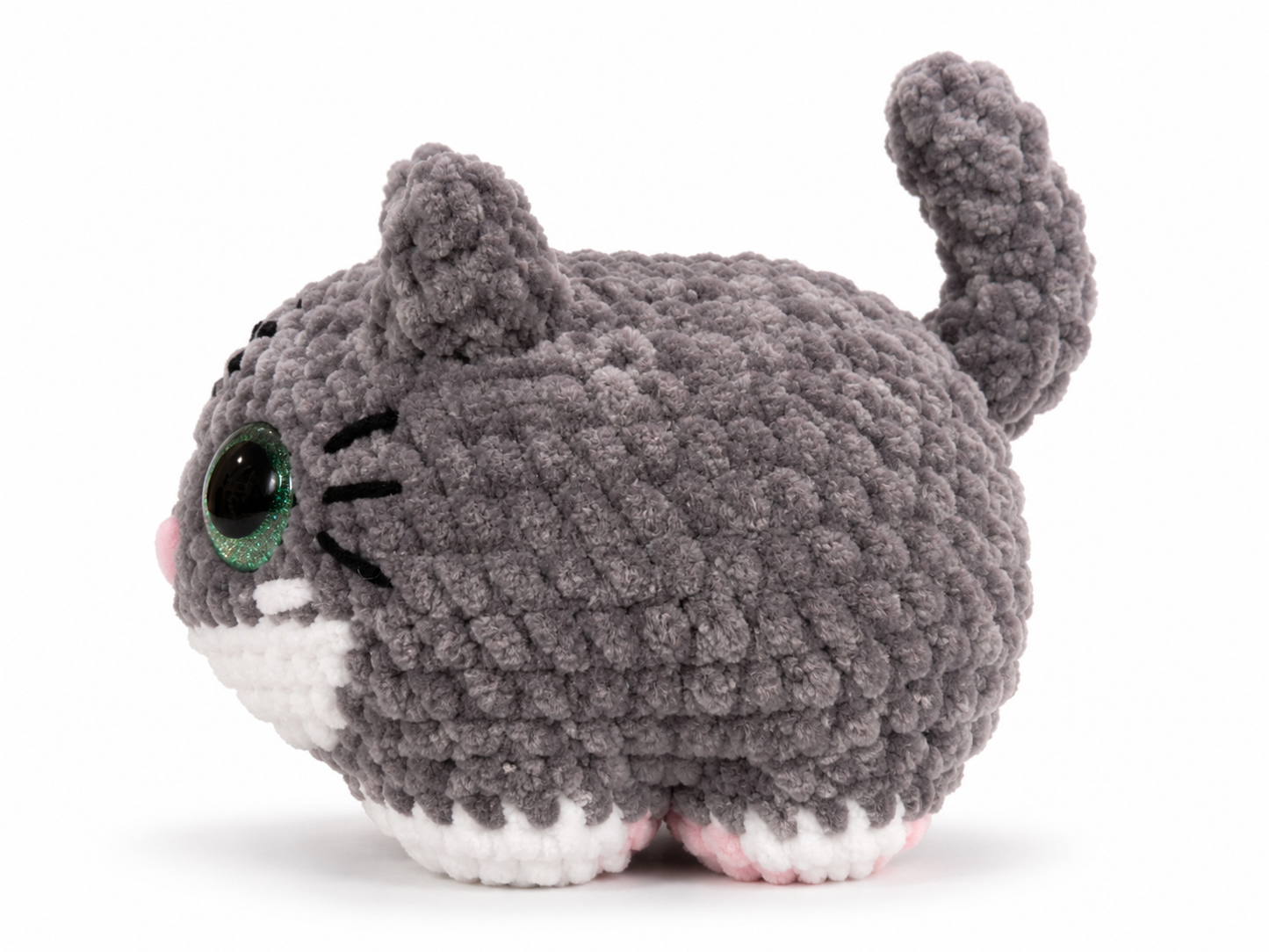 Plush toy cat with gray fur, green eyes, and pink ears on a white background