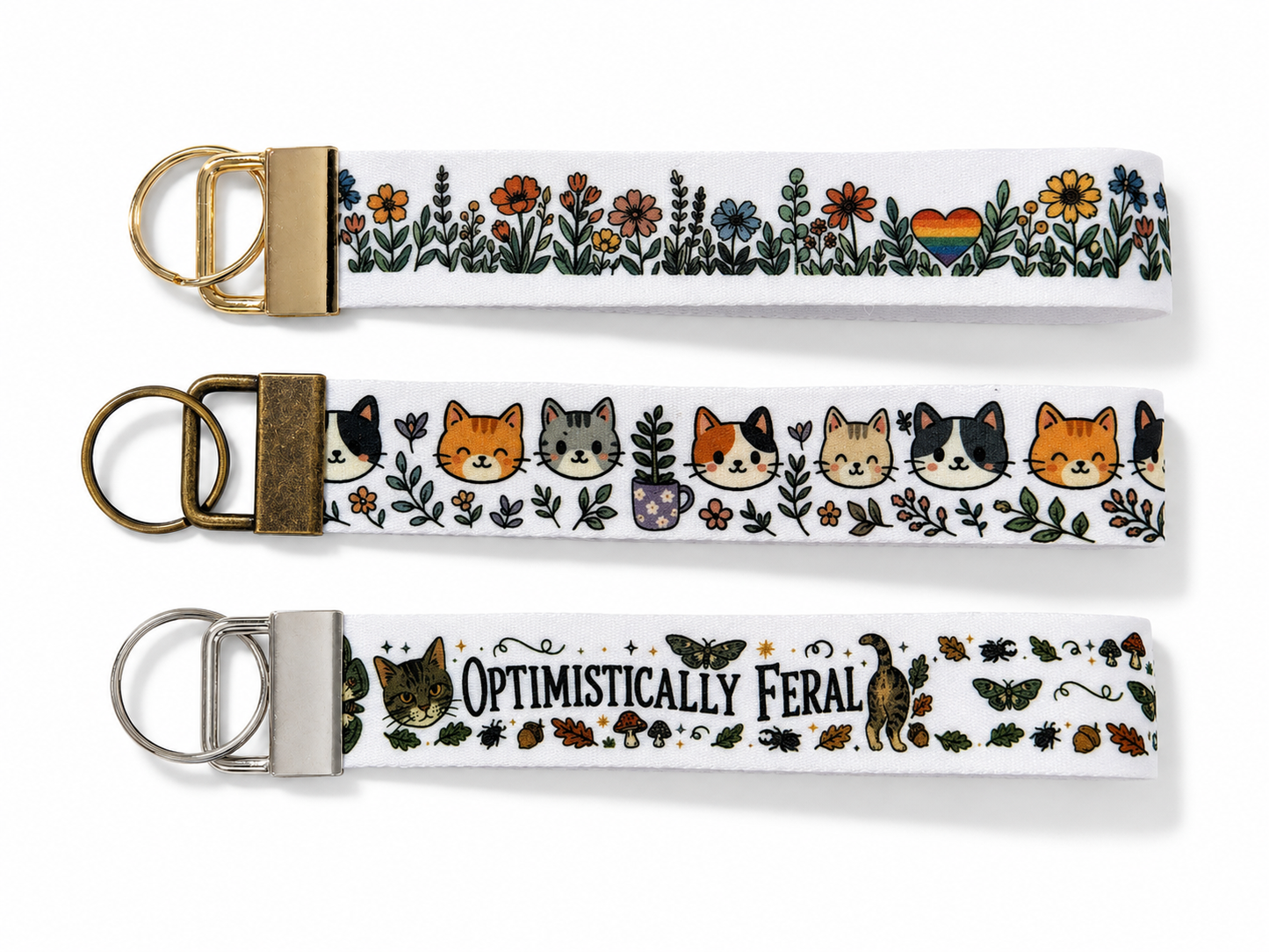 Three keychains with floral and animal designs on a white background