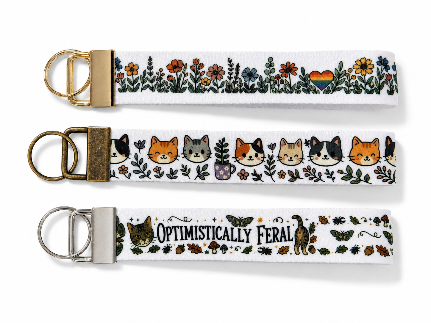Three keychains with floral and animal designs on a white background