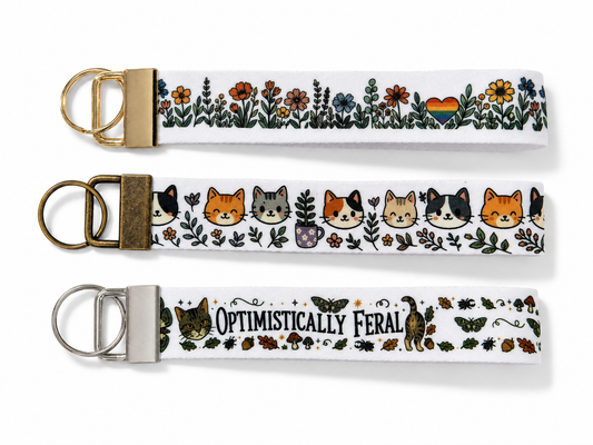 Three keychains with floral and animal designs on a white background