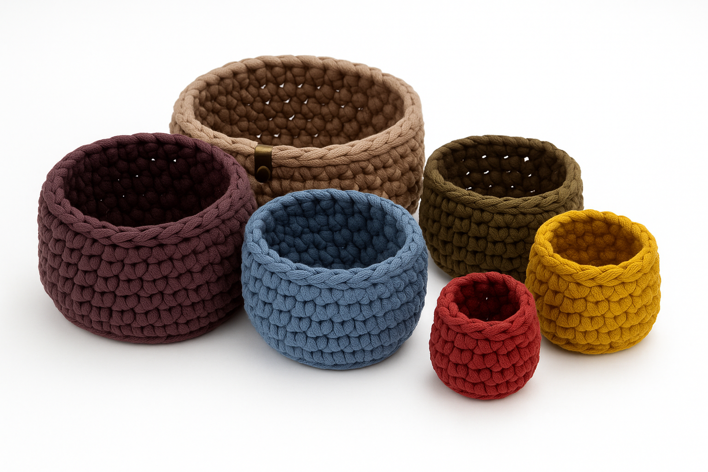 Six crochet nesting bowls arranged on a white surface, separated to show their individual sizes and earthy-toned colors. The bowls are staggered in a circular layout from smallest to largest.