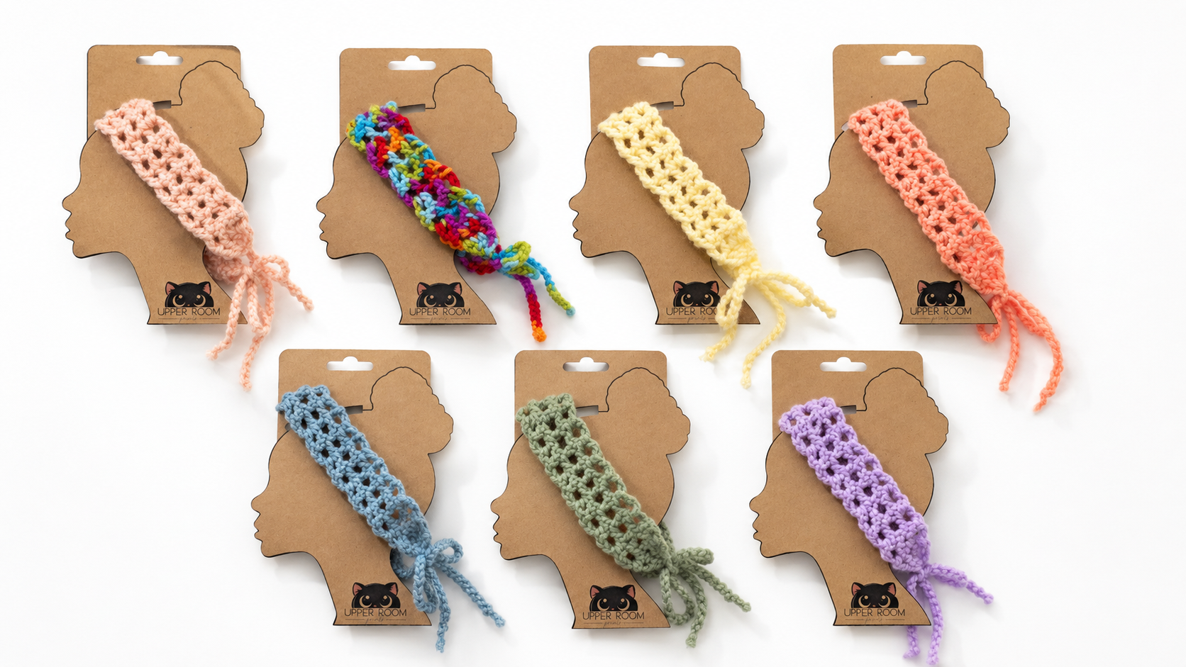 Set of colorful braided dog toys on cardboard packaging shaped like dog heads.