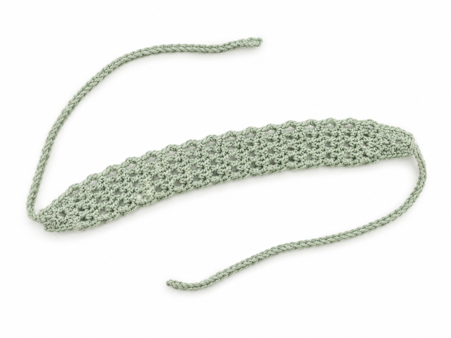 Green crocheted headband on a white background