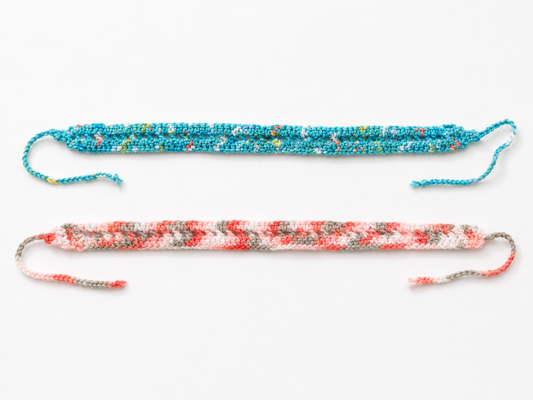 Two colorful braided bracelets on a white background