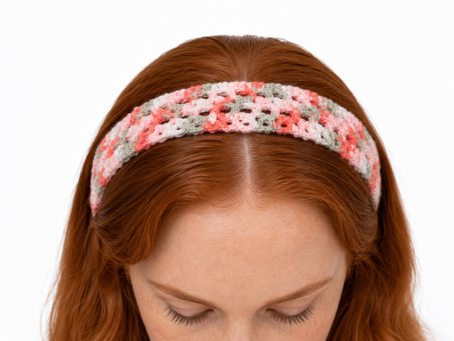 Woman wearing a colorful crochet headband on a white background