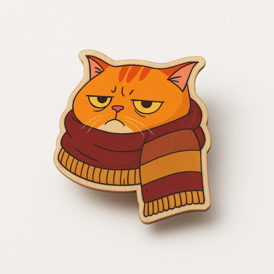 Cat-shaped brooch with a striped scarf on a light beige background