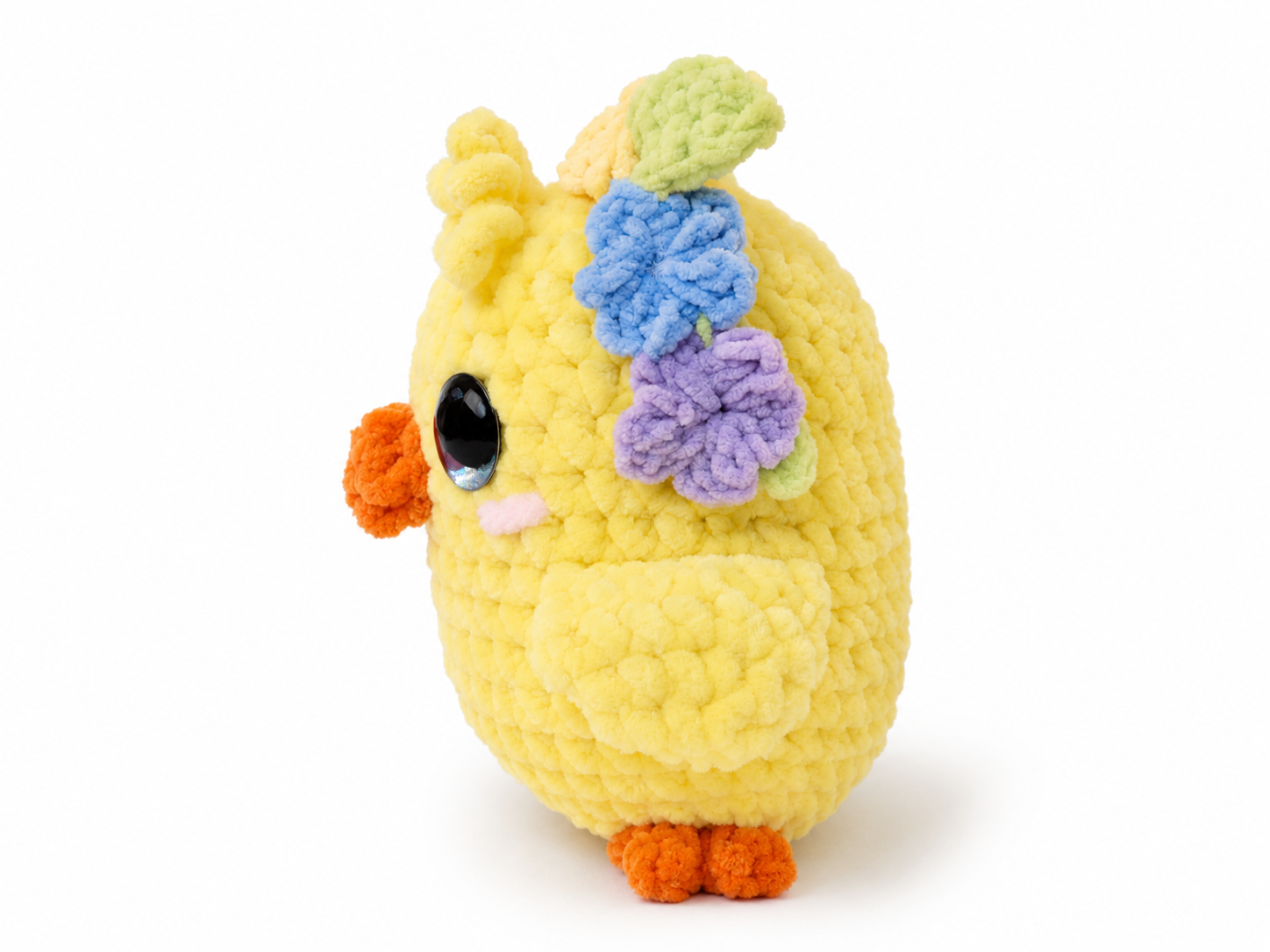 Yellow plush toy with floral decorations on a white background