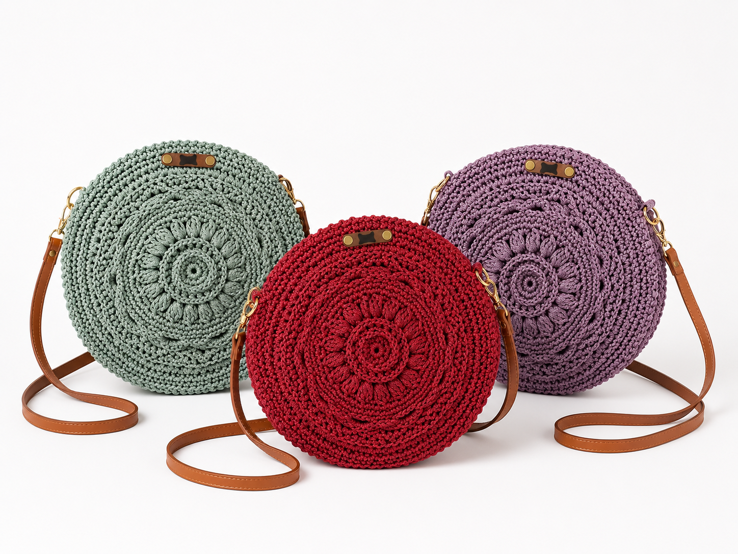 Three round crochet bags in green, red, and purple with brown straps on a white background.
