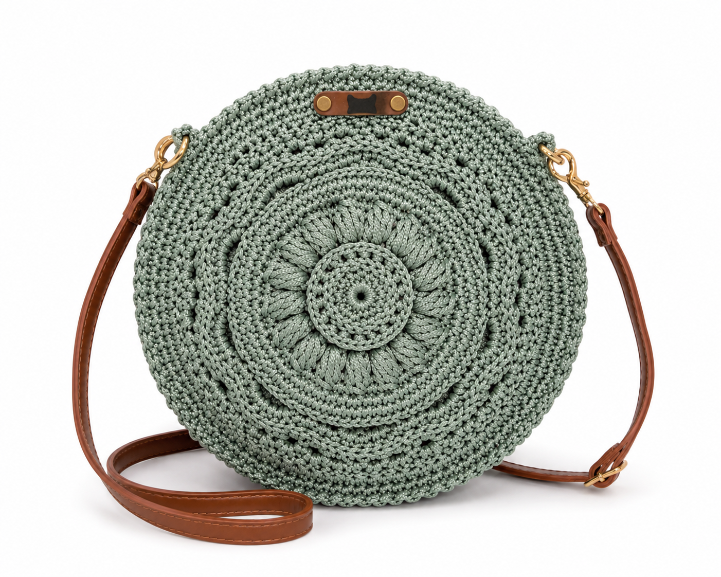 Round crochet bag with brown leather strap on a white background