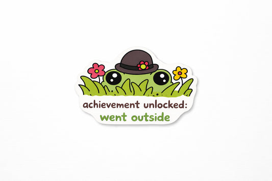 Sticker with a frog wearing a hat and flowers, text 'achievement unlocked: went outside', on a white background