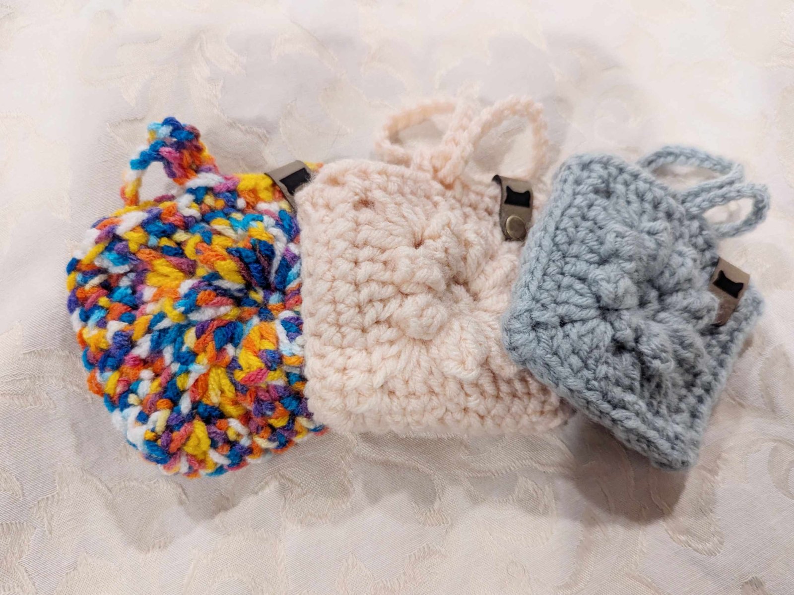 Handmade crochet Boho Bag Charm in rainbow, white, and blue color combinations. A unique granny square purse charm perfect for boho and cottagecore accessories.