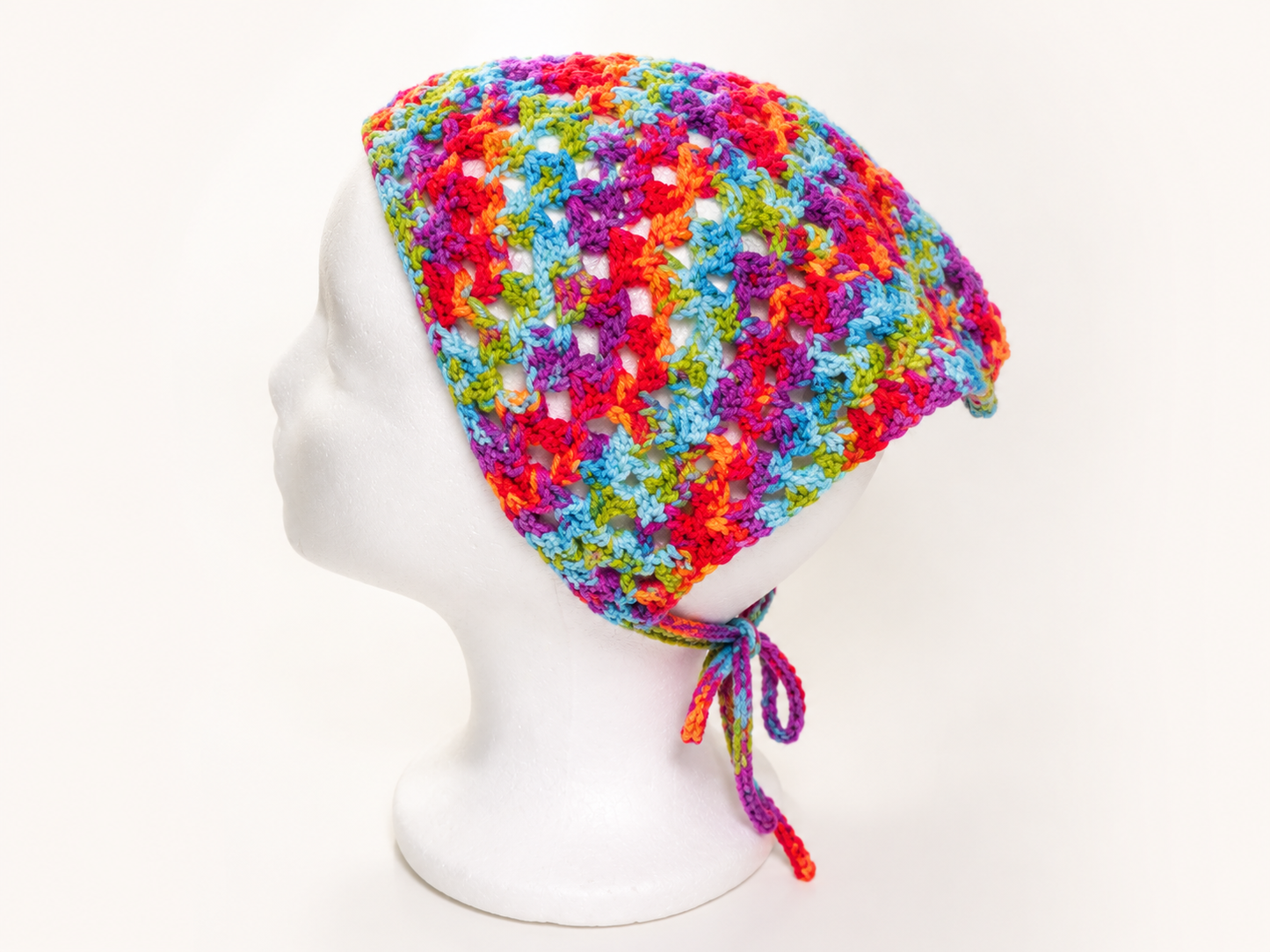 Colorful knitted hat on a mannequin head against a white background