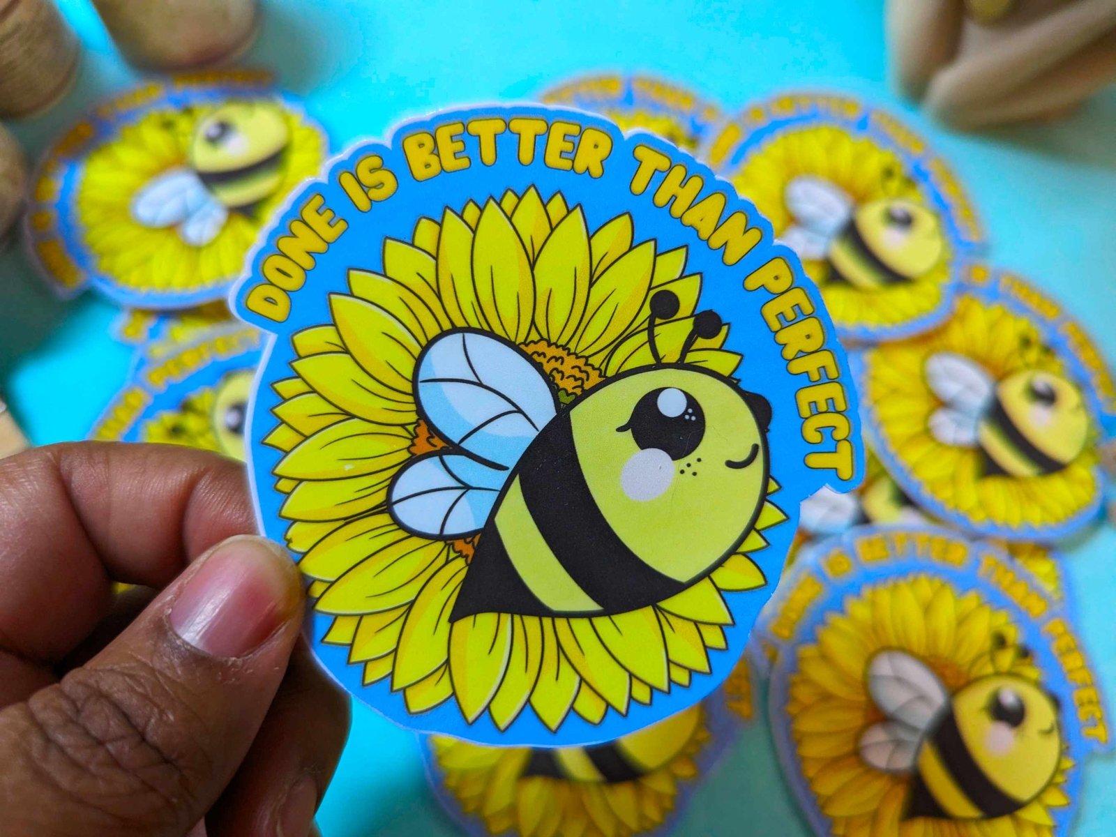 Done is Better than Perfect Sticker held in fingers, showcasing its 3-inch waterproof vinyl design for laptops, planners, and bottles.