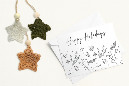 Happy Holidays greeting card with three handmade crochet star ornaments in white, green, and tan with wooden beads