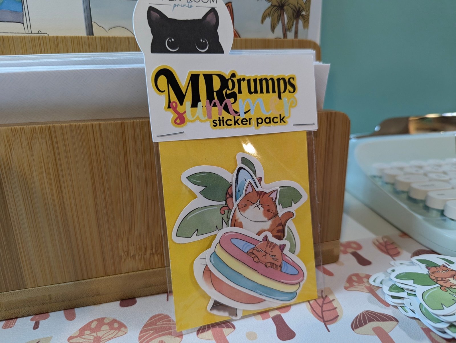 Mr. Grumps Summer Sticker Pack inside its packaging, showing a set of 5 waterproof vinyl stickers featuring the grumpy orange cat.
