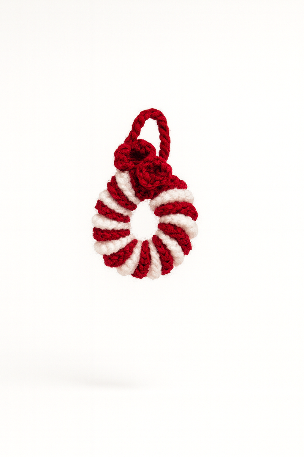 Red and white crochet wreath ornament with decorative bow for holiday tree