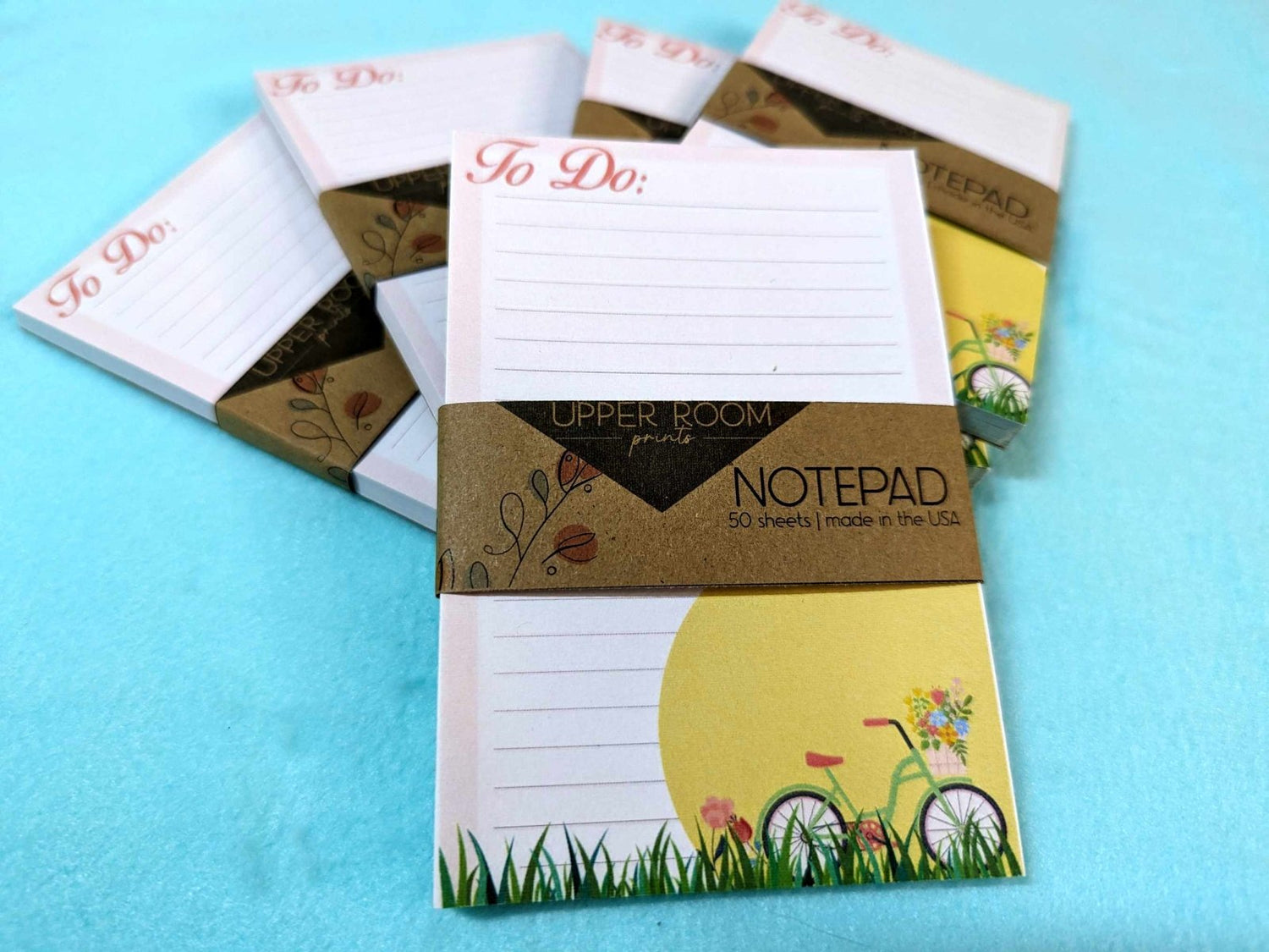 Stack of Spring Cycle Notepads showing floral bicycle cover design on multiple 4x5 stationery pads