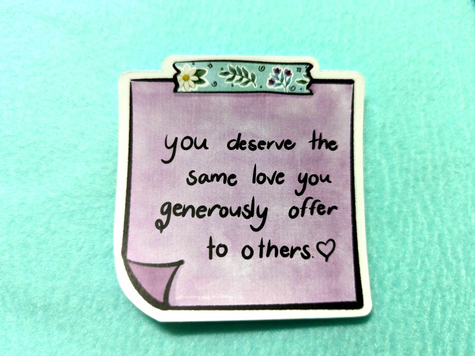 Close-up of the You Deserve Sticker, showcasing its uplifting design and high-quality waterproof vinyl finish